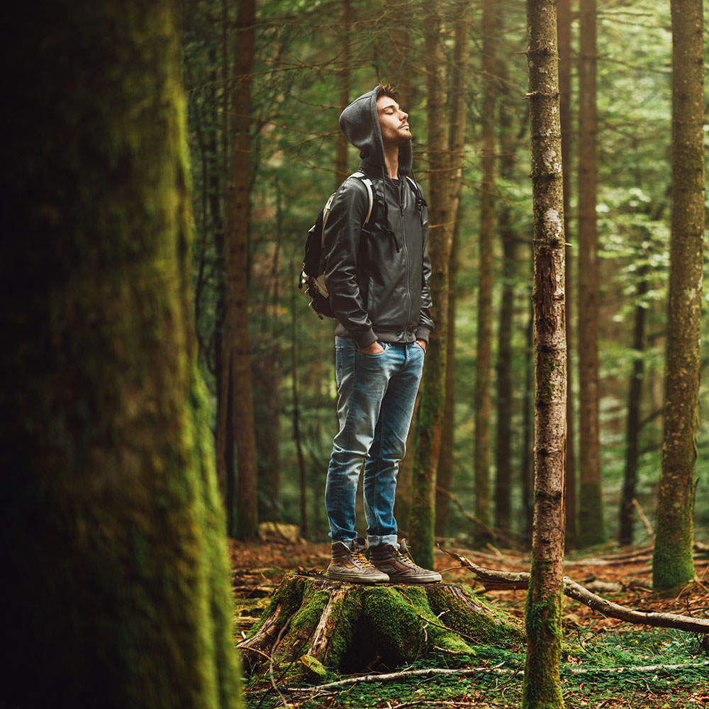 Calm young man enjoying the forest